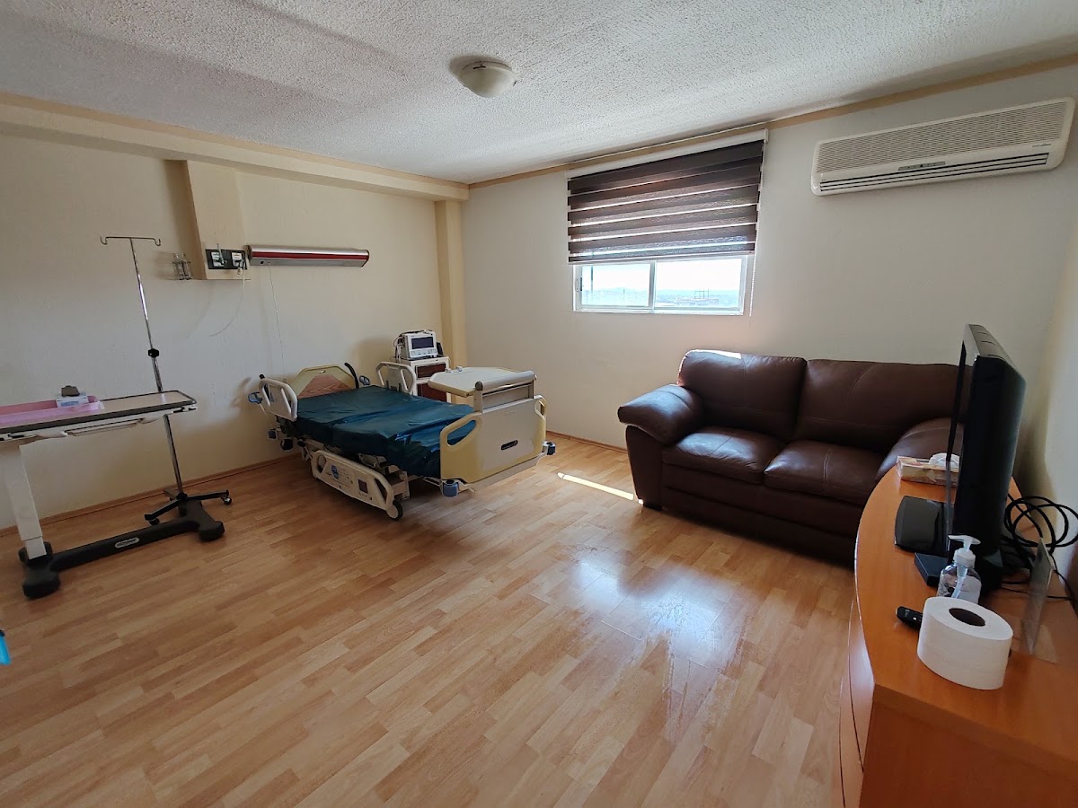 Recámara con cama hospitalaria, sofá y ventana